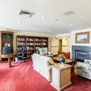 A cozy living room featuring a fireplace, bookshelf, and comfortable seating.