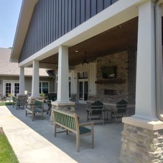 A spacious outdoor patio area featuring comfortable seating and elegant columns.