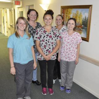 A group of healthcare professionals in uniforms standing in a hallway.