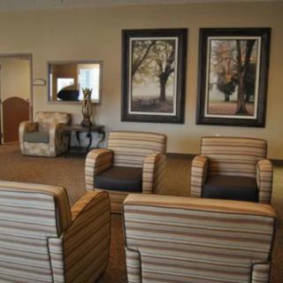 A cozy waiting room with striped armchairs and framed artwork.