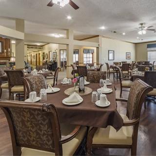 An elegantly set dining area with multiple tables and chairs, featuring detailed table settings.