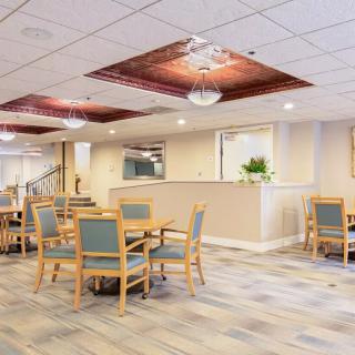 A modern dining area with tables and chairs, featuring stylish ceiling lights.
