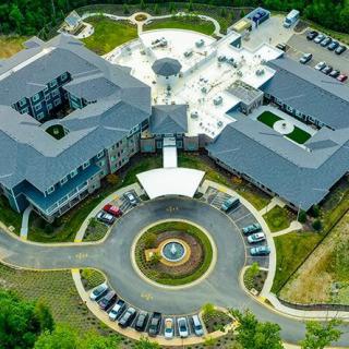 Aerial view of a large building complex with a circular driveway and parking lot.