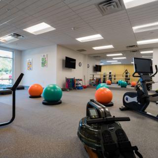 A spacious gym equipped with exercise balls and cardio machines, designed for fitness activities.