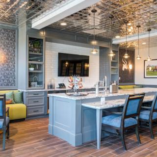 A modern kitchen and dining area with a stylish ceiling and island counter.
