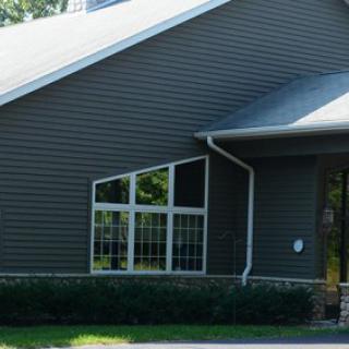 A residential building with large windows and dark siding.