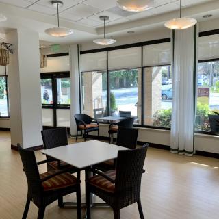 A bright and modern dining area with large windows and comfortable seating.
