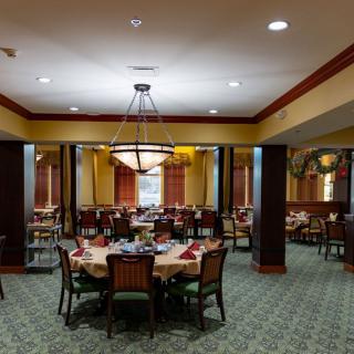 Elegant dining room with neatly arranged tables and chandelier lighting.