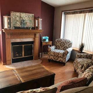 Cozy living room with a fireplace and patterned armchairs.