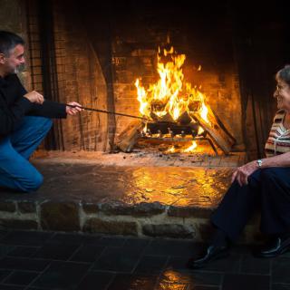 Two people enjoying a cozy evening by the fireplace.