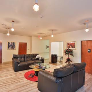 A modern living room with comfortable sofas, stylish lighting, and decorative artwork.