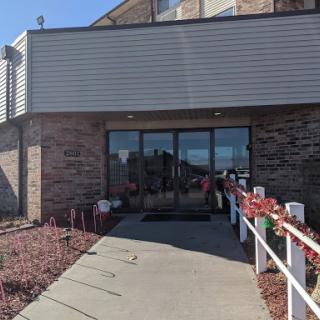 The entrance of a commercial building with a clean walkway and decorative plants.