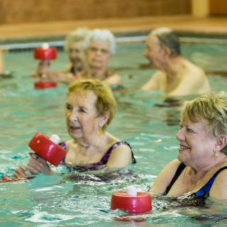 A group of seniors participating in water aerobics in a swimming pool.