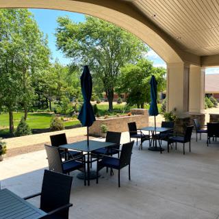 A serene outdoor dining area with a beautiful view of greenery, perfect for enjoying meals in the sun.