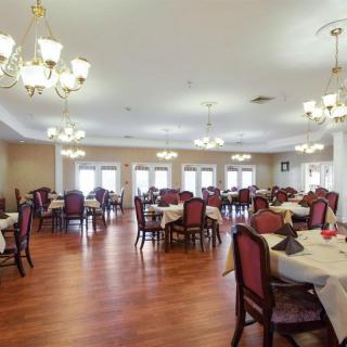 Spacious dining room with elegantly arranged tables and chandeliers.