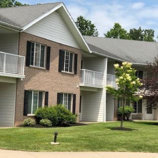 A residential apartment building with balconies and a well-maintained lawn.