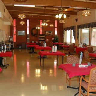 A cozy restaurant dining room with red tablecloths and decorated interior.