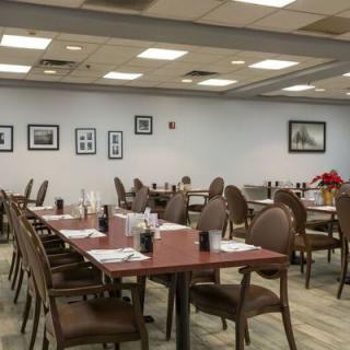 An empty restaurant dining area with neatly arranged tables and chairs.