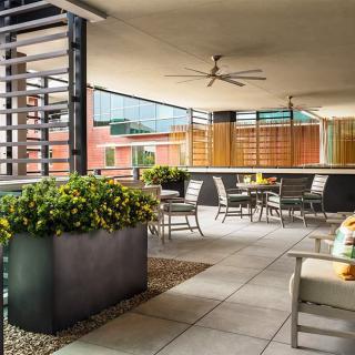 A modern outdoor patio with seating and plants, designed for a comfortable urban setting.