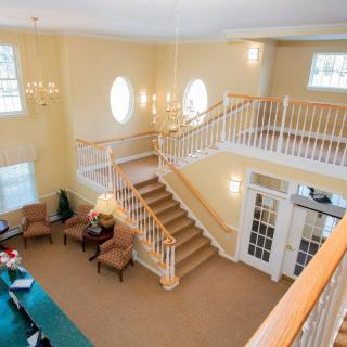 A spacious lobby with a grand staircase and chandelier.