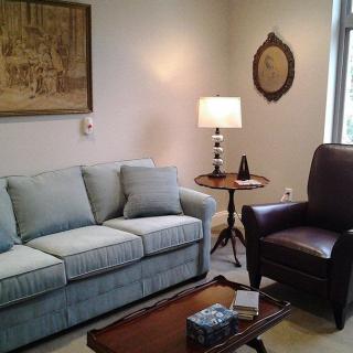 A cozy living room with a sofa, armchair, and a coffee table.
