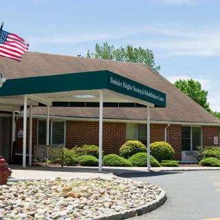An entrance to a building with a green canopy and an American flag.