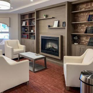 A cozy living room setup featuring a modern fireplace and comfortable seating.