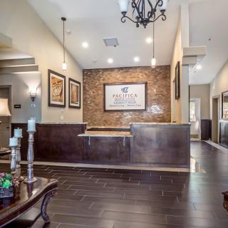 A modern office reception area with stylish decor, featuring wooden floors and artwork on the walls.