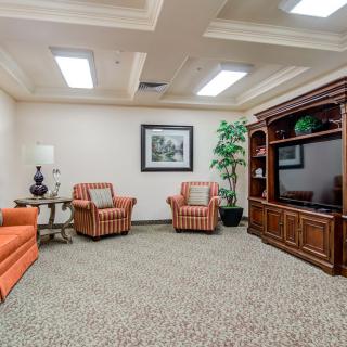 A cozy living room featuring comfortable seating, a large entertainment unit with a television, and tasteful decor.