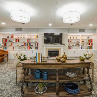A cozy living room with elegant lighting, a central fireplace flanked by bookshelves, and stylish decor on the table.