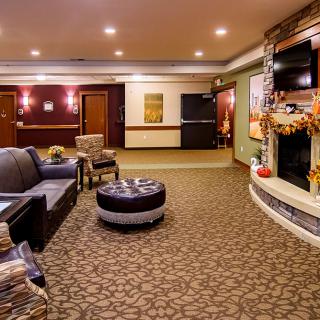 A cozy hotel lobby with comfortable seating and a decorative fireplace.