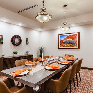 A beautifully decorated dining room with a set table, surrounded by stylish chairs and contemporary artwork on the walls.
