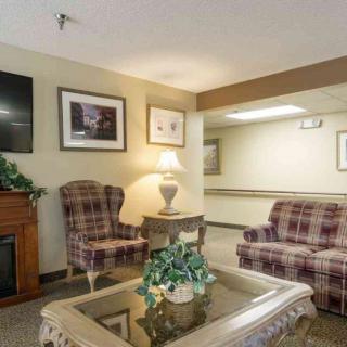 A cozy living room area with plaid armchairs, a wooden table, and decorative elements.
