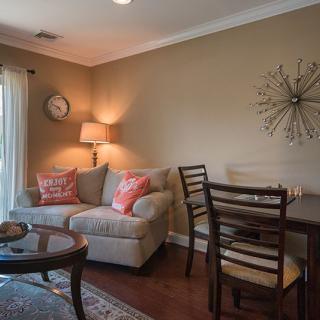 A cozy living room with a sofa, dining table, and warm lighting.