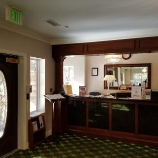 A hotel reception area with a front desk and decorative interior.