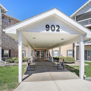 The entrance to apartment number 902, featuring a welcoming design and outdoor seating.