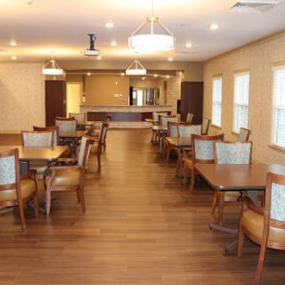 A modern dining area featuring wooden furniture and warm lighting, designed for community gatherings.