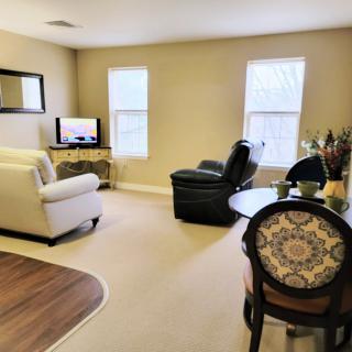 A cozy living room featuring a sofa, chair, TV, and decorative elements.