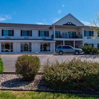 A sunny day at a charming motel with well-maintained landscaping.