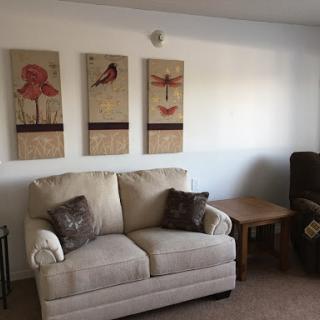 A cozy living room featuring a comfortable sofa and decorative artwork on the wall.
