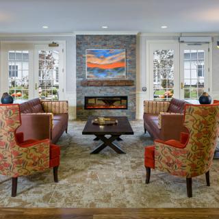 A modern living room with a fireplace, comfortable seating, and vibrant artwork.