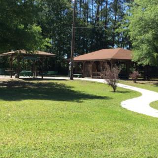 A sunny day at the park with a pavilion and winding pathway.