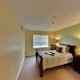 A cozy bedroom with a neatly made bed, bedside tables, and soft lighting.