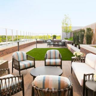 A comfortable and stylish outdoor patio with seating area and greenery.