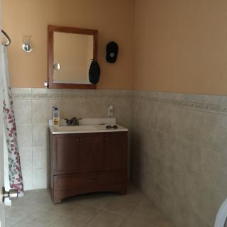 A tidy bathroom with a vanity sink and mirror, featuring tiled walls.