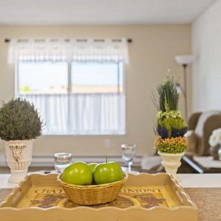 A cozy living room with a decorative tray featuring green apples and potted plants.