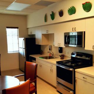 A modern kitchen with stainless steel appliances and decorative elements on top of the cabinets.