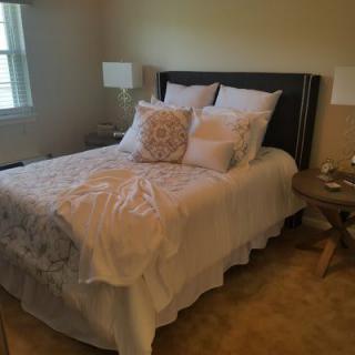 Cozy bedroom with a neatly made bed and decorative pillows.