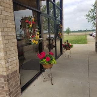 A vibrant display of flowers in planters at the entrance of a building.