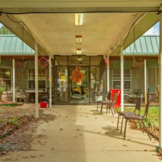 A welcoming entrance with chairs and seasonal decorations under a canopy.